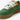 En detaljbild på en vegansk MoEa GEN 9 Pineapple Yellow & Green Suede sneaker. Skon har en djupt grön mockaöverdel med perforeringar över tån. Kontrasterande detaljer i gul syns på sidan och runt snörningen, vita, breda skosnören. Skons plös är vit och med en vit etikett med varumärkets namn i svart text på. Skon har en gul hälkappa. Sulan är i en ljusbrun, gummiaktig textur. Bilden är mest fokuserad på skon snörning.
