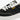 En detaljbild på  MoEa GEN 4 Banana Black & White veganska sneaker i svart och vitt. Fokuserad på skon sida med logga och de vita skosnörena.